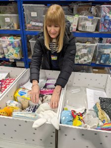 Volunteer packing a baby box with newborn essential items